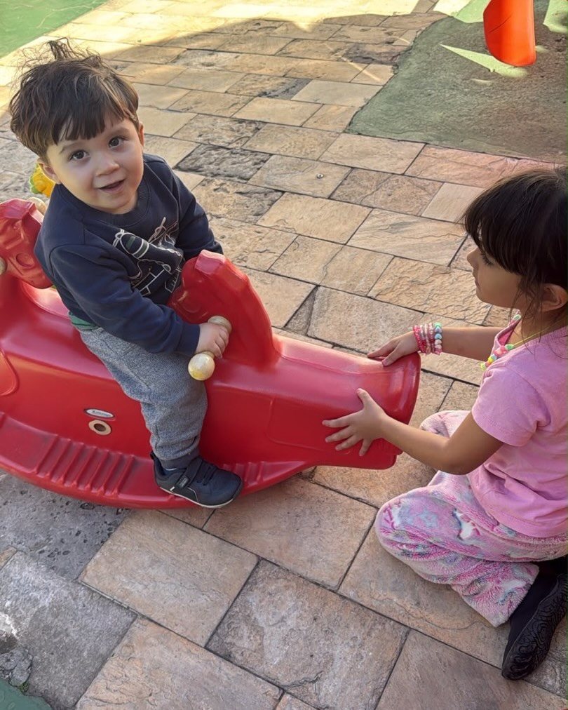 Menino em brinquedo de balanço no pátio