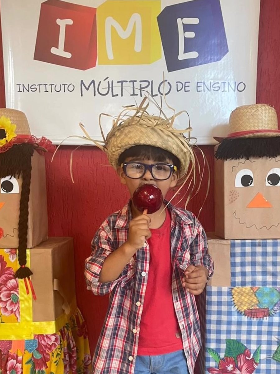 Aluno com maçã do amor em frente ao painel do IME