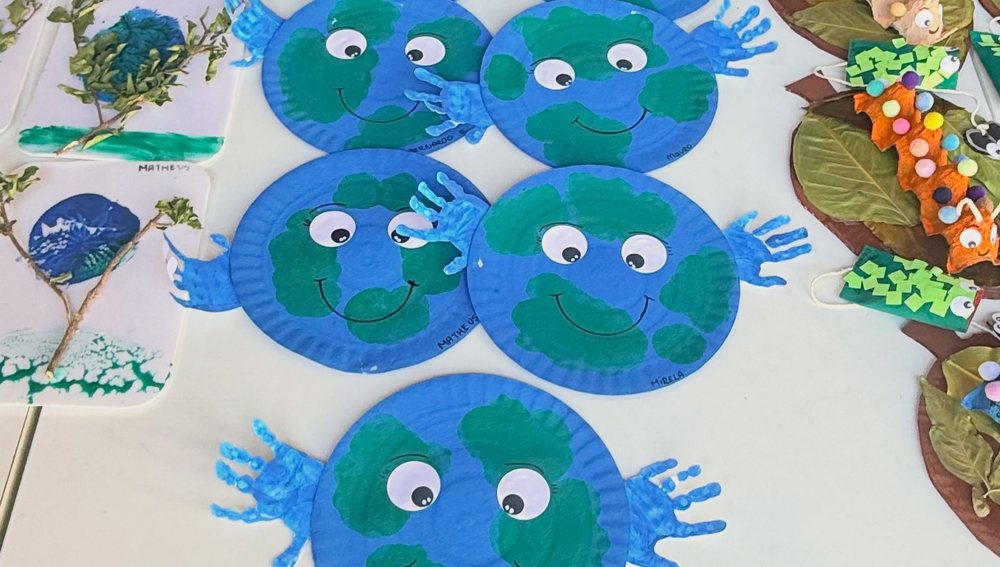 Planetas Terra de prato de papel com mãozinhas pintadas