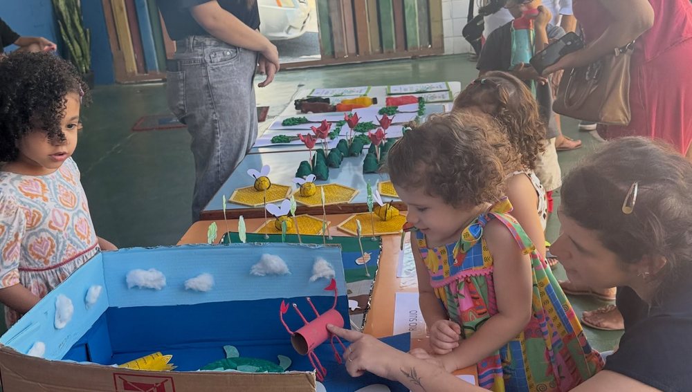 Alunas mostrando a maquete do rio feita em sala