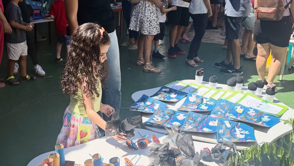 Aluna mexendo nos trabalhos de papel da turma
