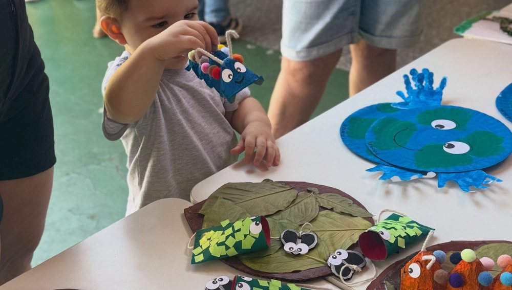 Aluno segurando a Terra de papel com mãozinhas pintadas